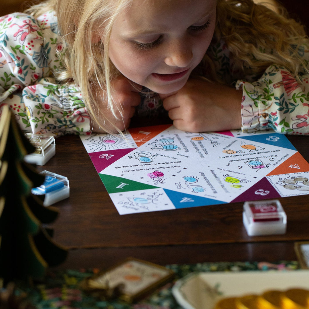 Young girl playing with a colourful board game on a wooden table.