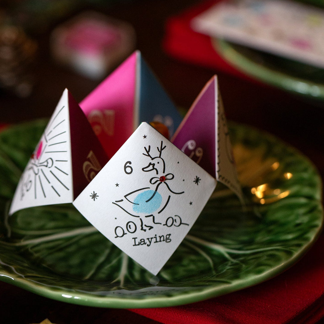Three colourful paper joke tellers on a green plate with a blurred background