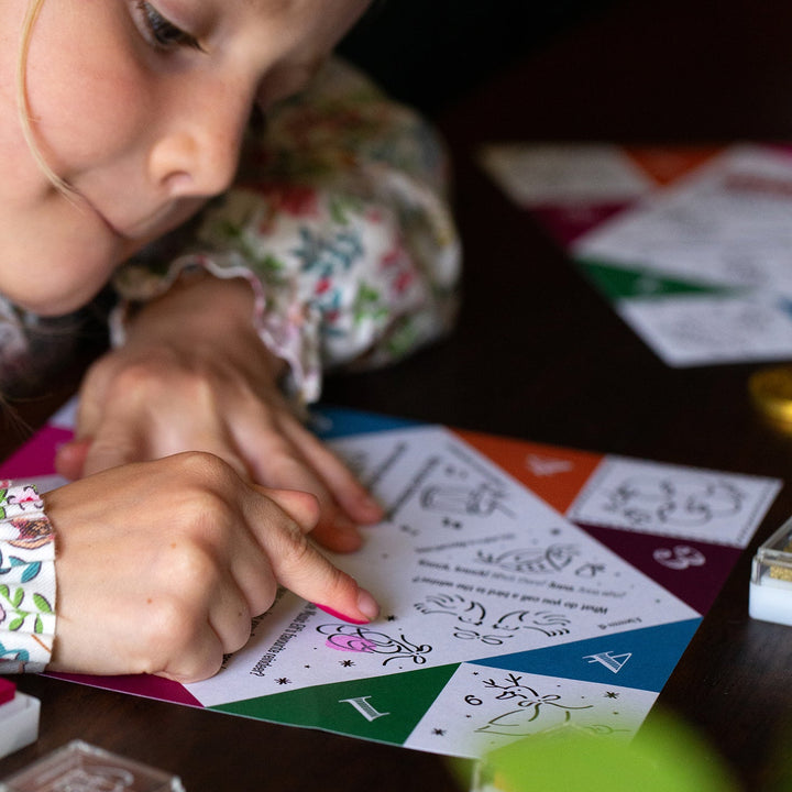 Child playing with a colourful game board on a wooden table