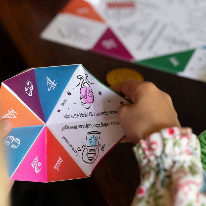 Colourful origami paper joke teller with text and symbols on a table