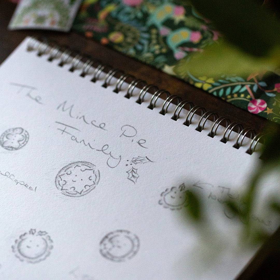 Notebook with sketches and text on a floral-patterned fabric background