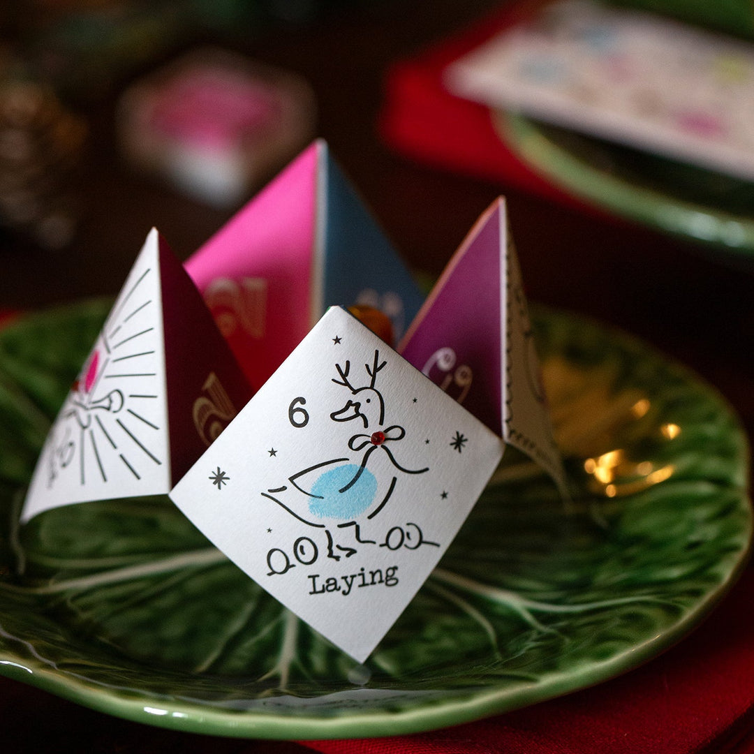 Three colourful Christmas paper joke teller on a green plate with a blurred background